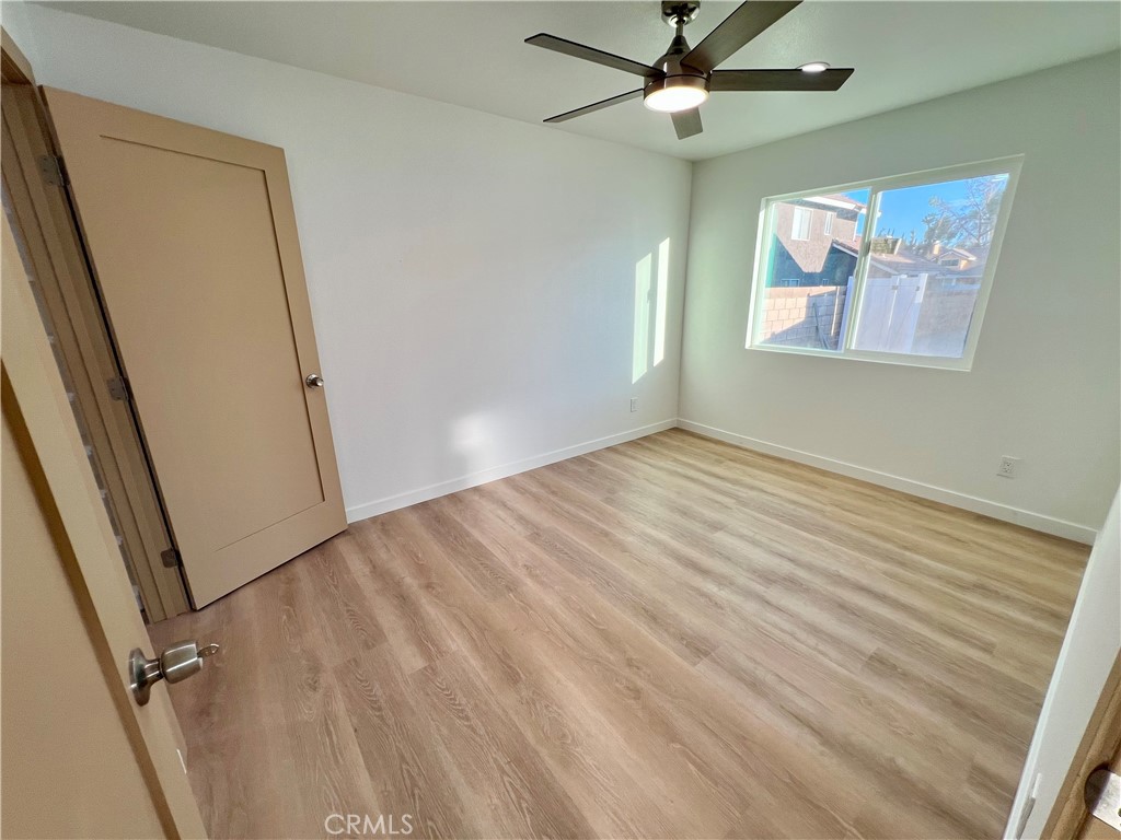 1133 Geraldine Avenue East, Unit B Lancaster, CA 93535 - Photo 12 of 27 wooden floor in an empty room with a window