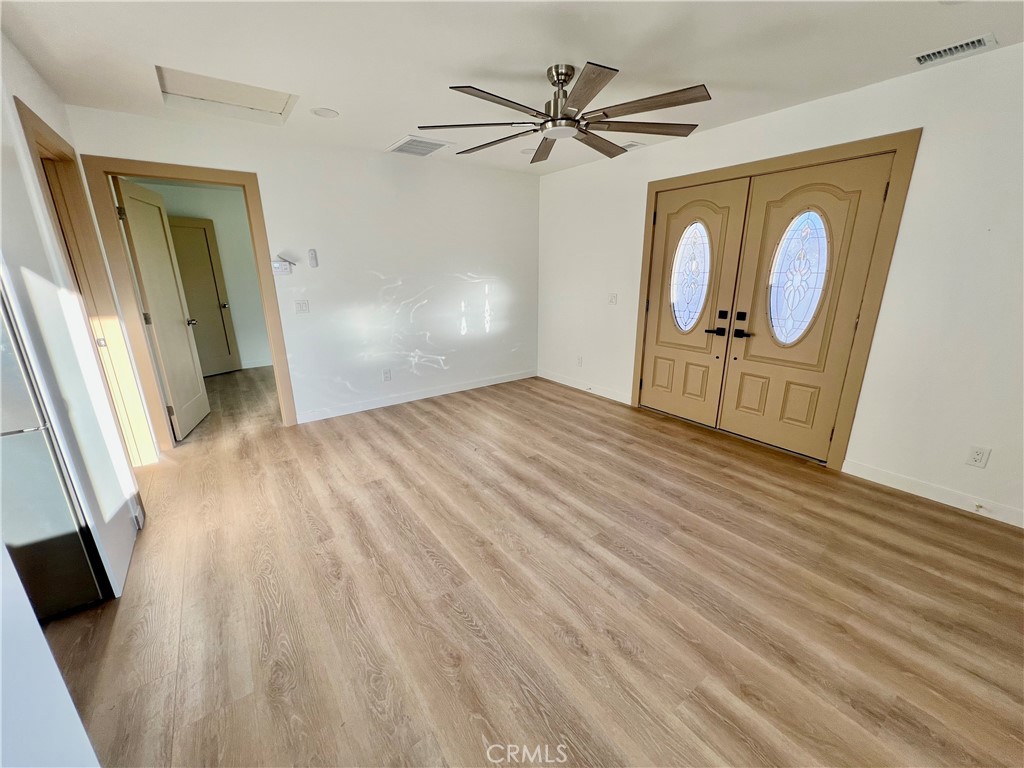 1133 Geraldine Avenue East, Unit B Lancaster, CA 93535 - Photo 3 of 27 a view of an empty room with wooden floor and a window