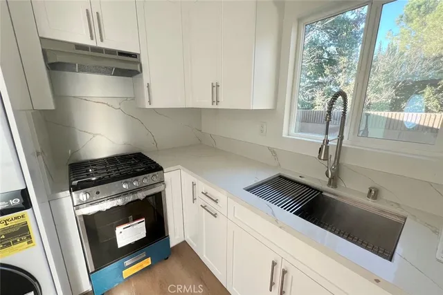 a kitchen with a stove and white cabinets