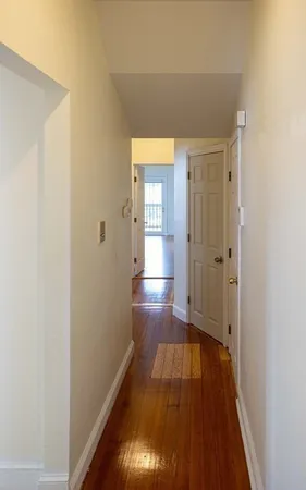 a view of a hallway with wooden floor