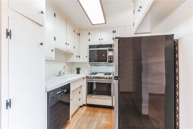 a kitchen with stainless steel appliances a refrigerator sink and cabinets