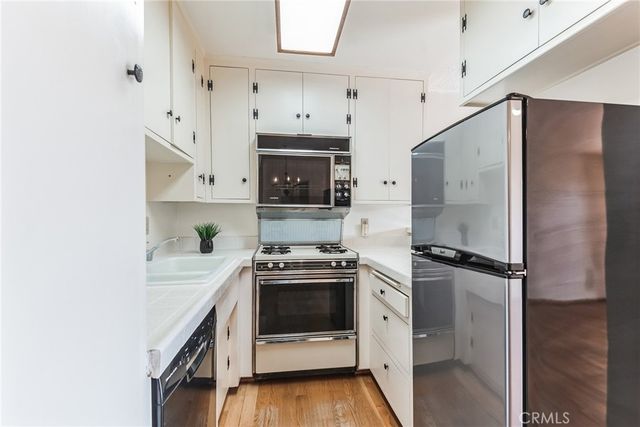 a kitchen with stainless steel appliances a sink stove and refrigerator