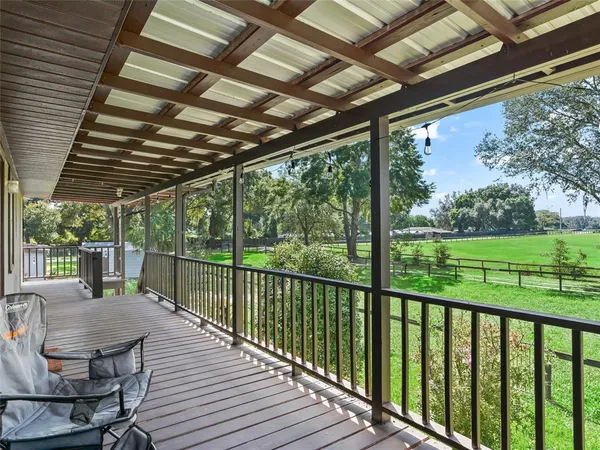 a view of a balcony with chairs and wooden floor