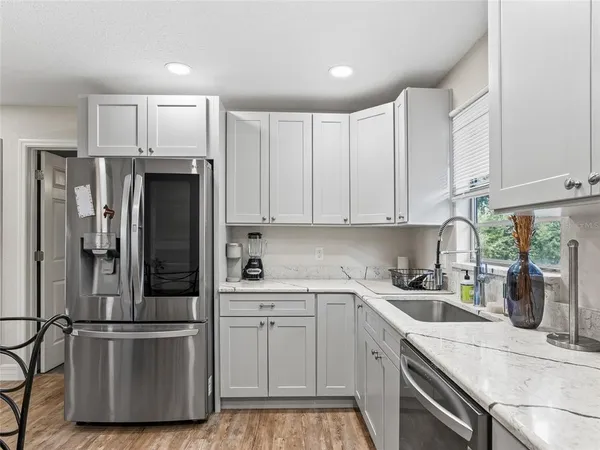 a kitchen with stainless steel appliances a refrigerator sink and cabinets
