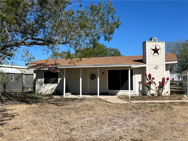 a view of a house with backyard and porch