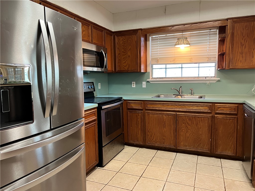 24748 County Road 350 Mathis, TX 78368 - Photo 4 of 16 a kitchen with stainless steel appliances granite countertop a refrigerator sink and microwave