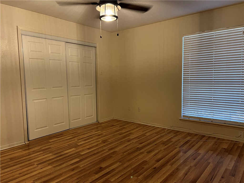 24748 County Road 350 Mathis, TX 78368 - Photo 7 of 16 an empty room with wooden floor cabinet and windows