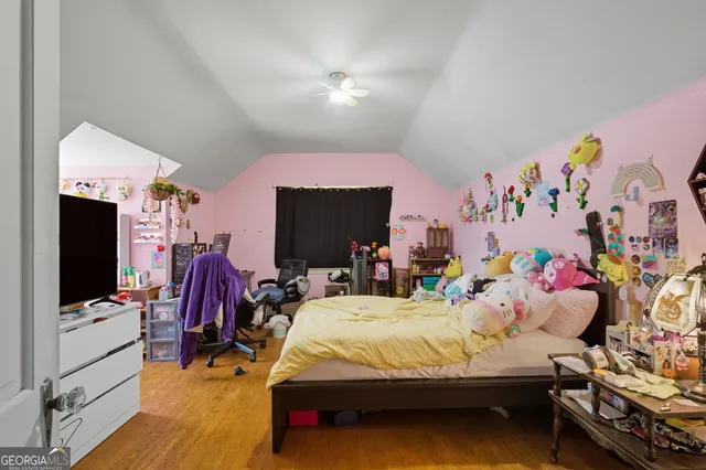 a bedroom with bed and a flat tv screen on dresser