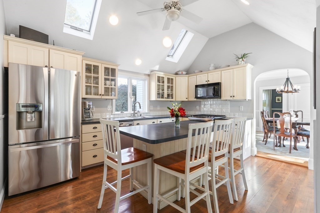 79 Kendall Lane Natick, MA 01760 - Photo 6 of 32 a kitchen with stainless steel appliances granite countertop a refrigerator a stove top oven a sink dishwasher and white cabinets with wooden floor