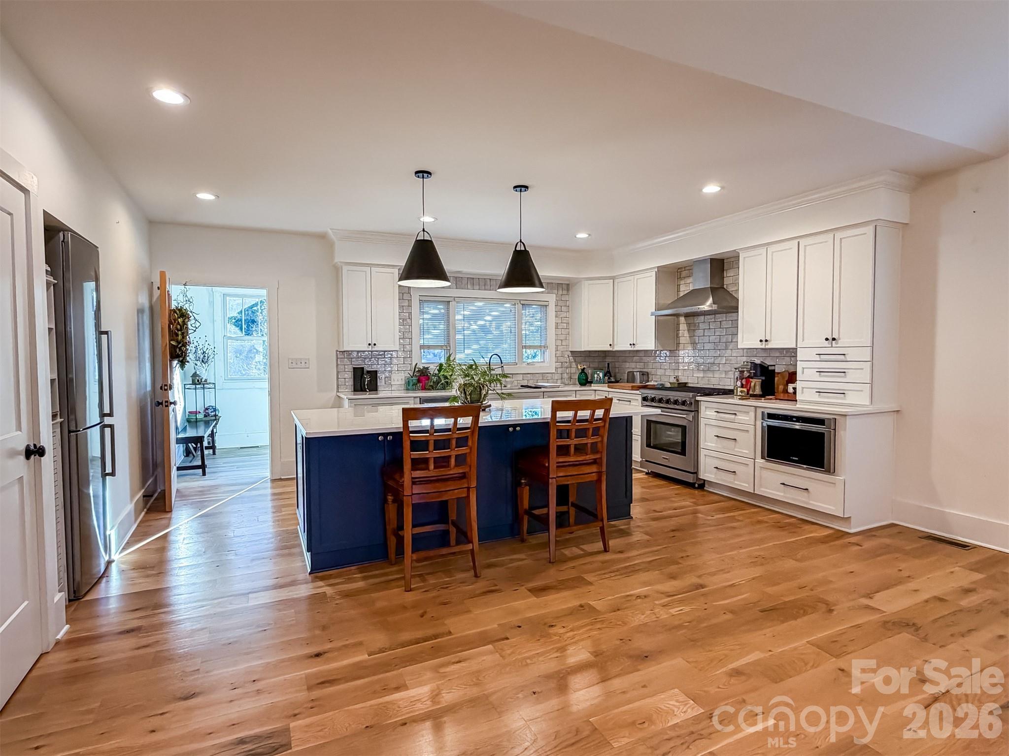 85 20th Avenue Northwest Hickory, NC 28601 - Photo 12 of 47 a kitchen with stainless steel appliances kitchen island granite countertop a refrigerator a stove top oven a sink dishwasher and white cabinets with wooden floor