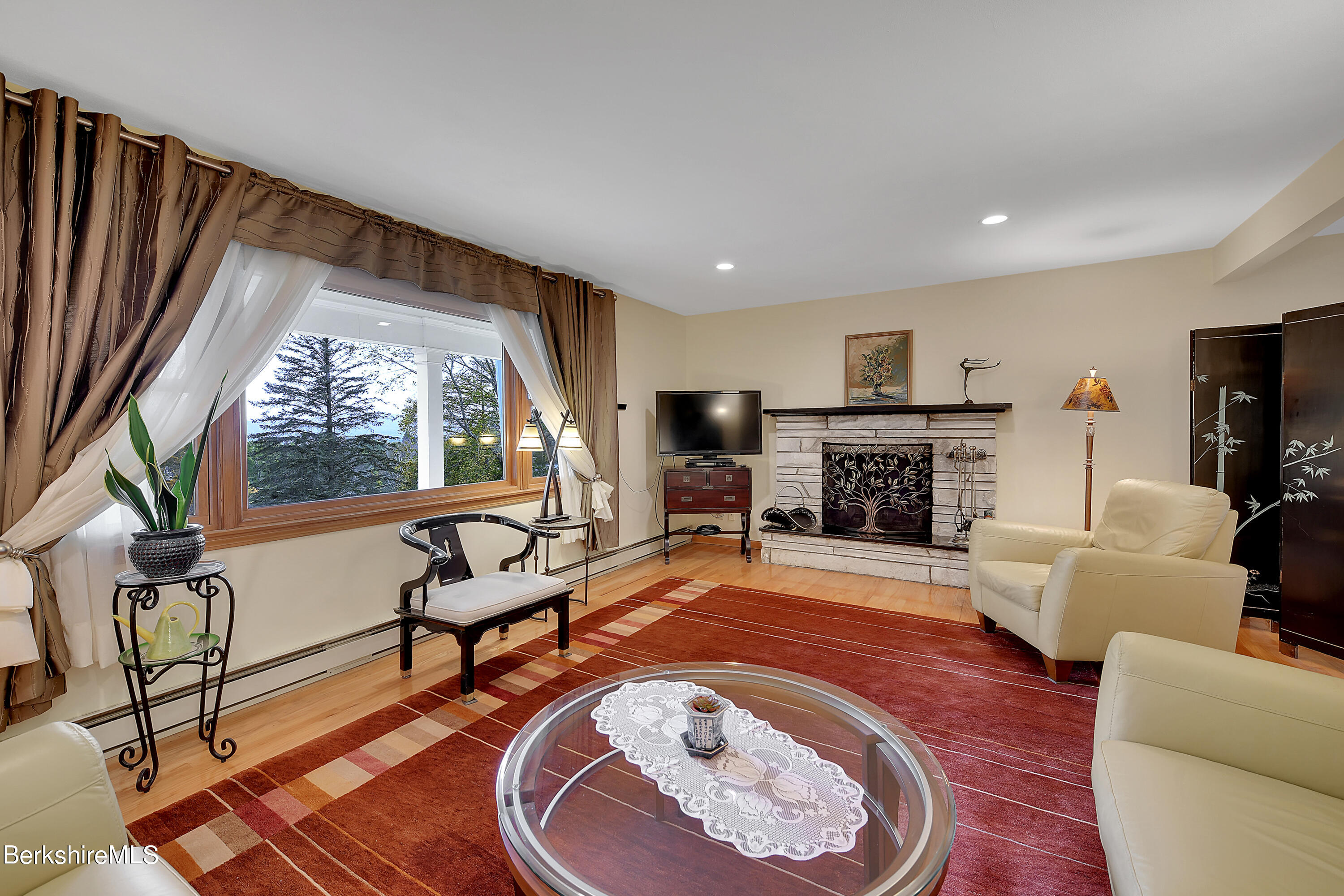 311 Yokun Road Richmond, MA 01201 - Photo 8 of 38 a living room with furniture a fireplace and a flat screen tv