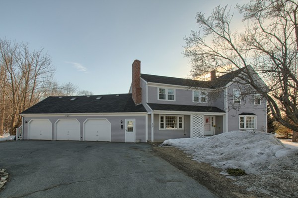 a view of a white house with a large tree