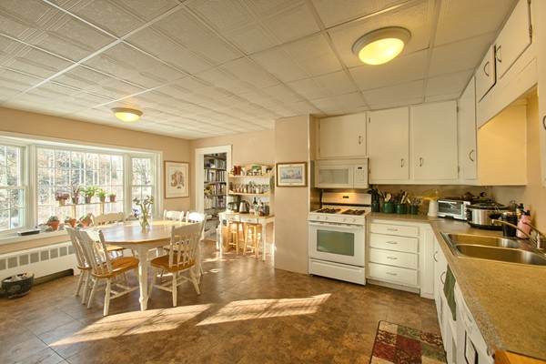 458 Johnson Street North Andover, MA 01845 - Photo 23 of 25 a kitchen with stainless steel appliances kitchen island granite countertop a stove a sink a dining table and chairs with wooden floor