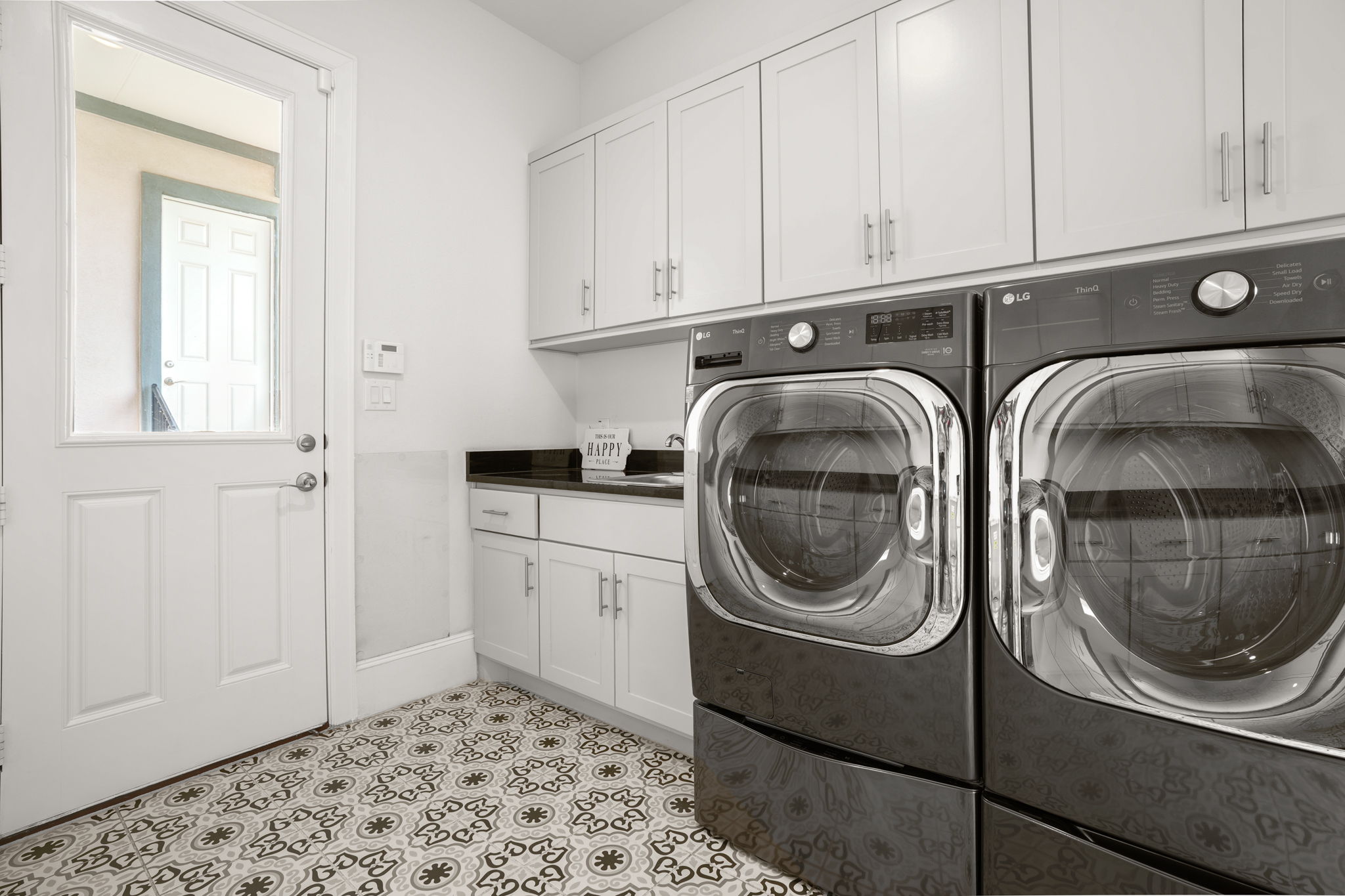 104 Lodestone Cove Austin, TX 78738 - Photo 33 of 40 A well-appointed laundry room features modern appliances, ample storage, and stylish patterned flooring.