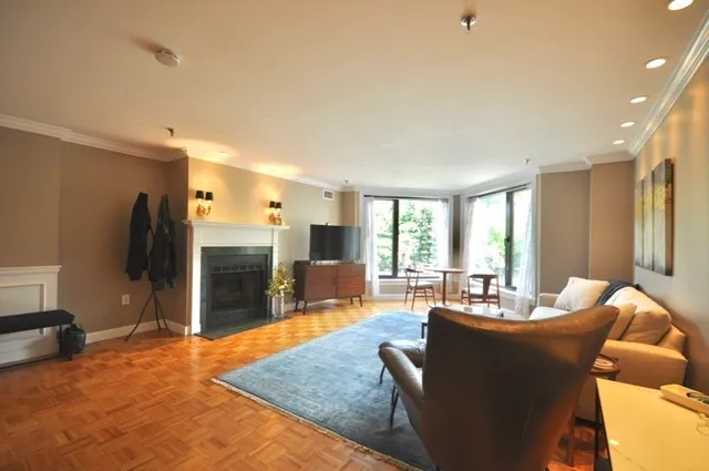 a living room with furniture kitchen view and a large window