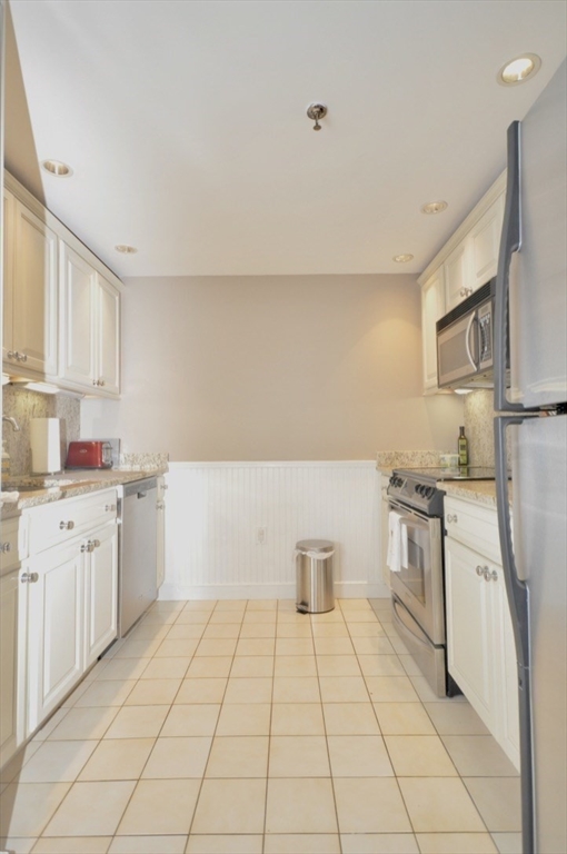 390 Commonwealth Avenue, Unit 210 Boston, MA 02215 - Photo 10 of 19 a kitchen with a sink a stove top oven and white cabinets