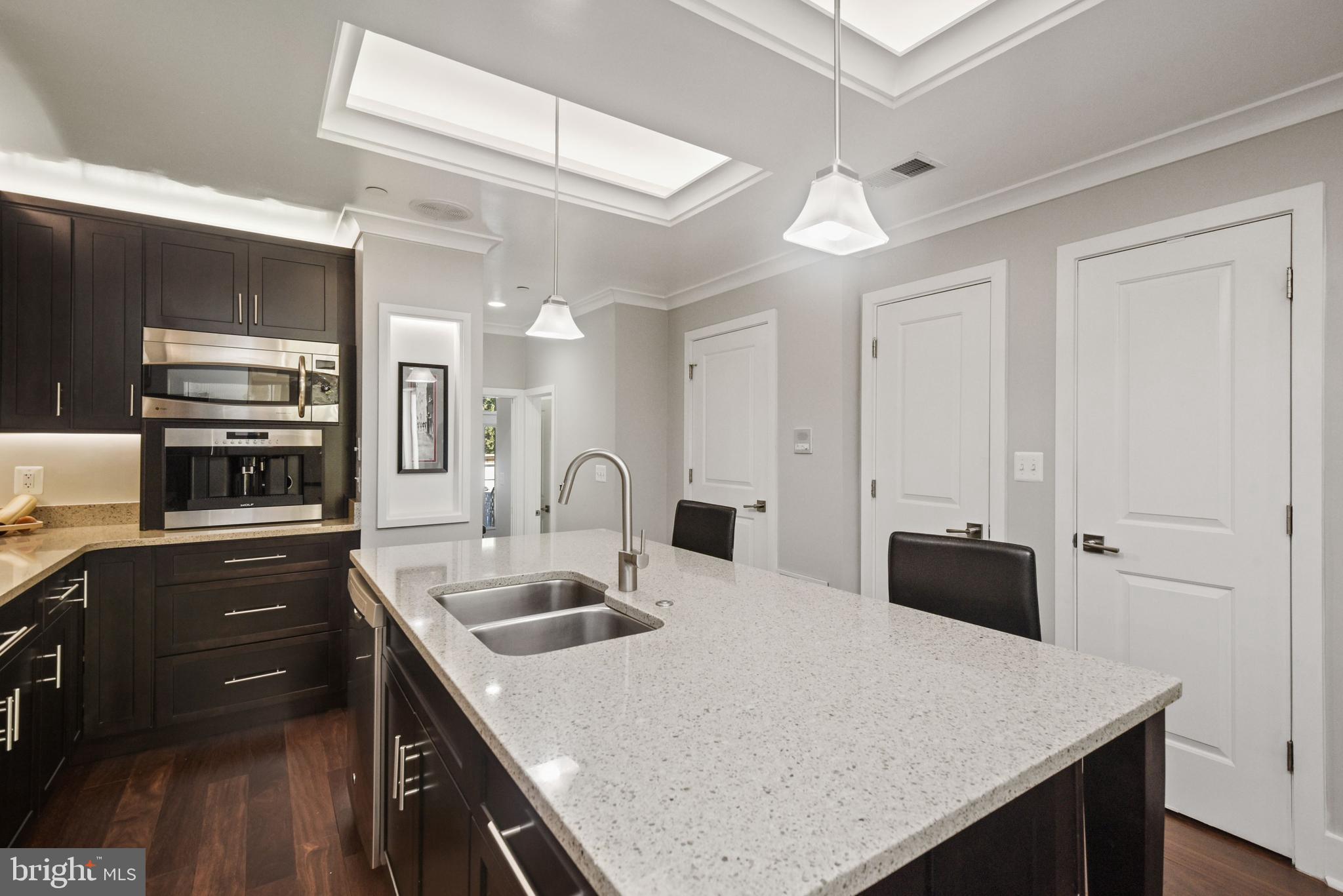 73 U Street Northwest, Unit 1 Washington, DC 20001 - Photo 8 of 30 a kitchen with stainless steel appliances a sink a stove a refrigerator cabinets and a dining table