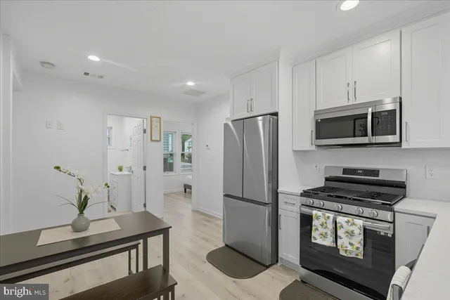 a kitchen with stainless steel appliances a refrigerator a stove a microwave and cabinets