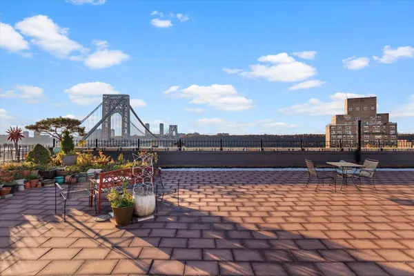 a view of roof deck with dining table and chairs