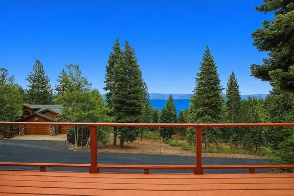 a view of a lake from a floor to ceiling window and a yard