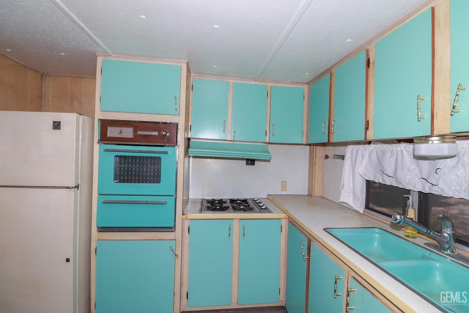Undisclosed Address Wofford Heights, CA 93285 - Photo 17 of 26 a kitchen with a refrigerator and a sink