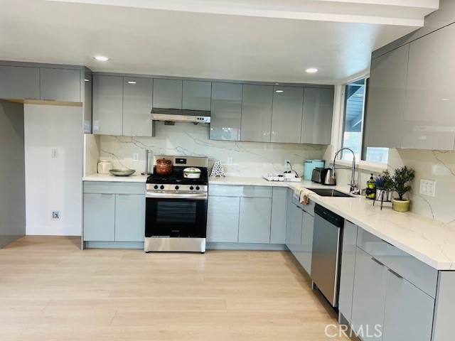 1135 Lockhaven Drive Brea, CA 92821 - Photo 16 of 35 a kitchen with a sink dishwasher a stove and a refrigerator with wooden floor