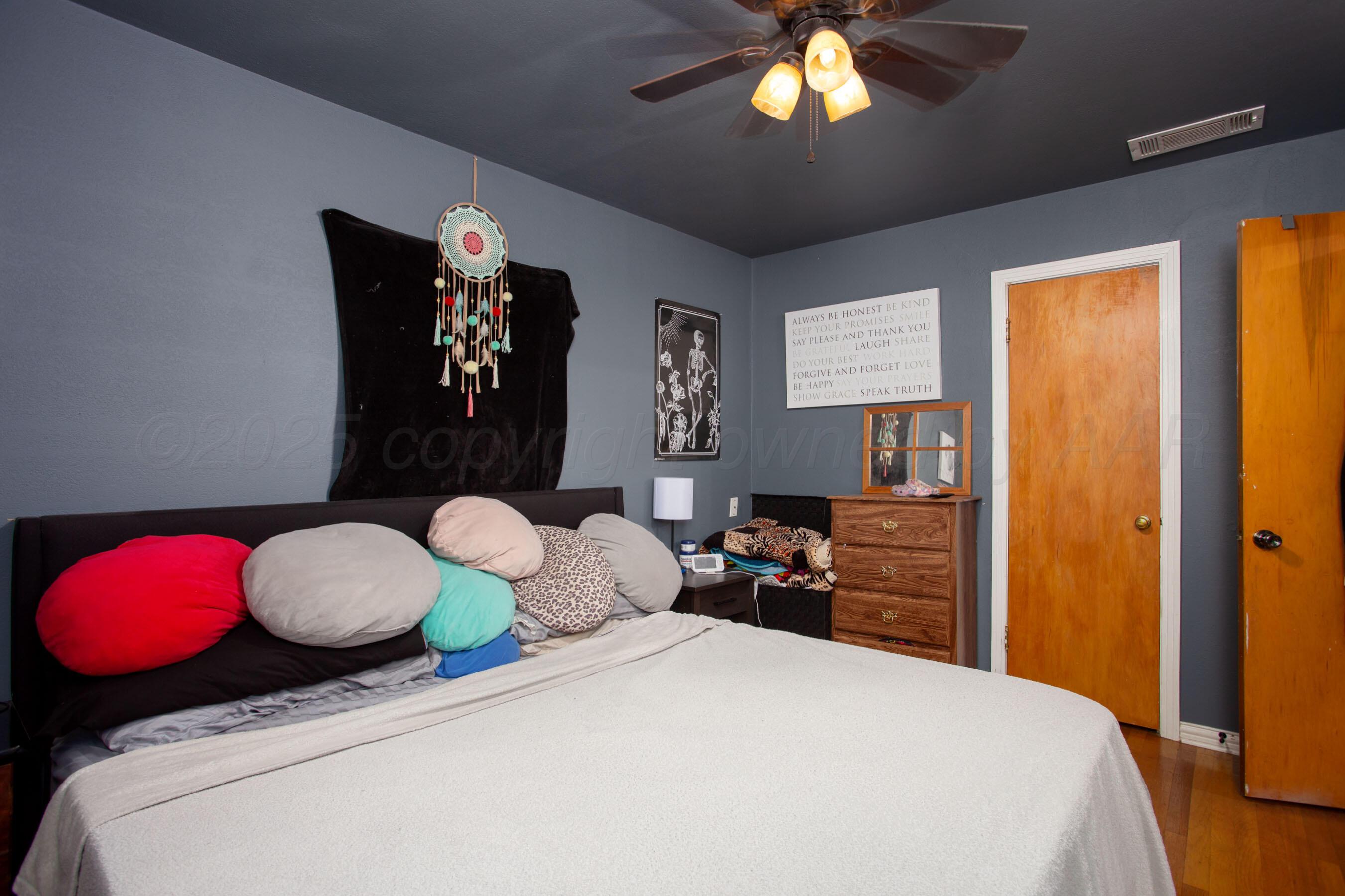 4409 South Lipscomb Street Amarillo, TX 79110 - Photo 15 of 23 a bedroom with a bed and a chandelier