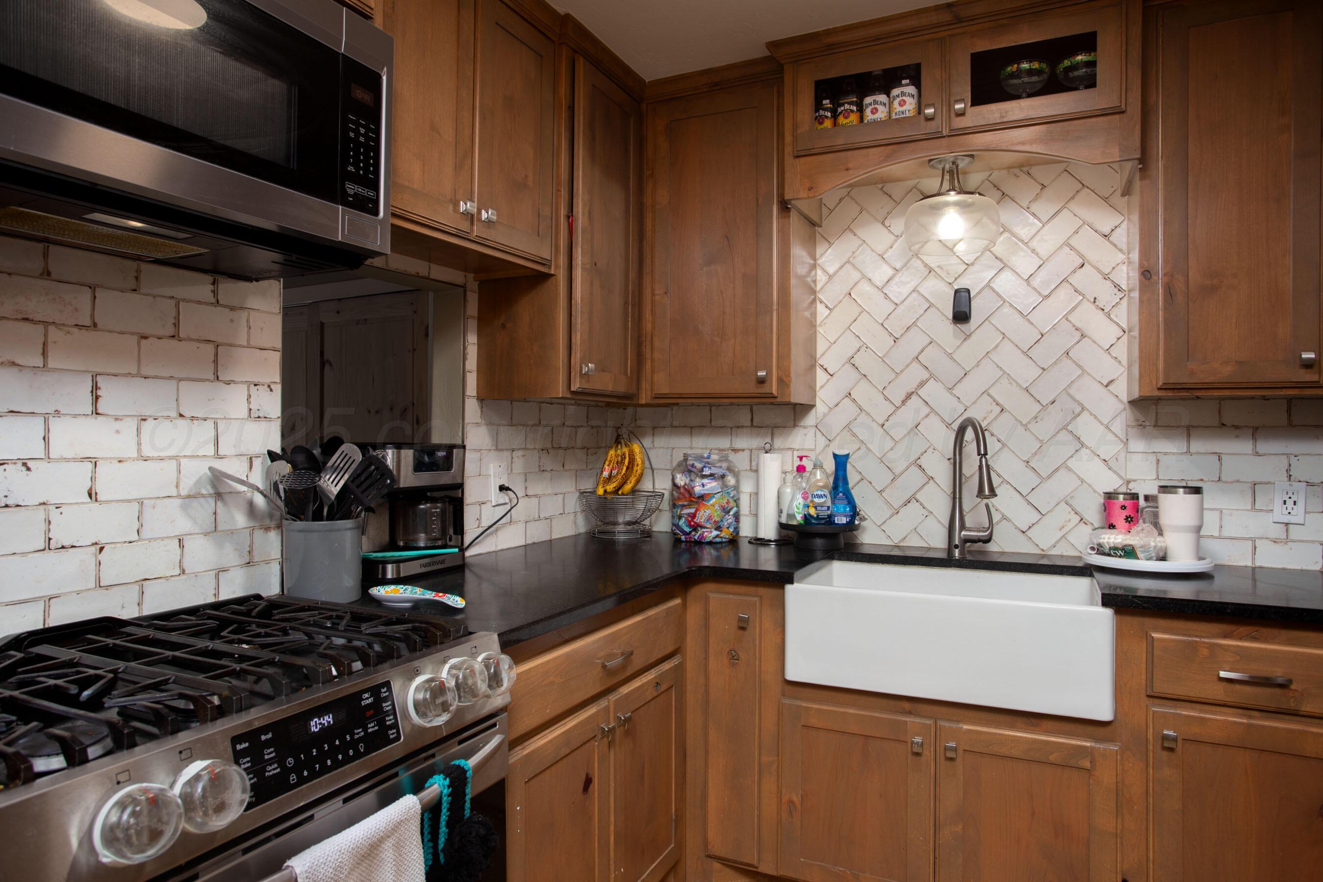 4409 South Lipscomb Street Amarillo, TX 79110 - Photo 8 of 23 a kitchen with stainless steel appliances granite countertop a stove and a sink