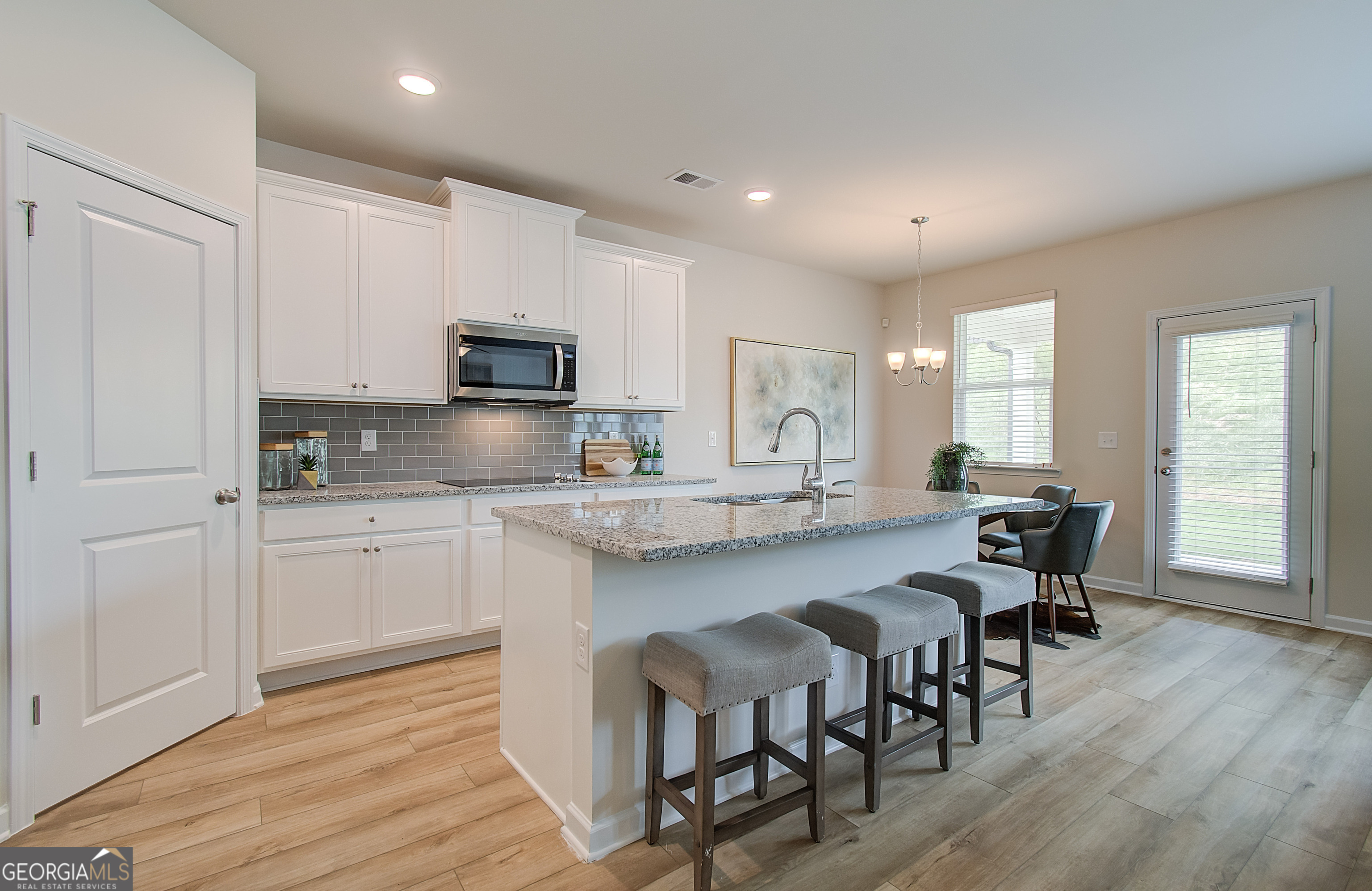 477 Collier Mls Road, Unit 20 Lawrenceville, GA 30045 - Photo 13 of 36 a kitchen with granite countertop a dining table chairs and granite counter tops