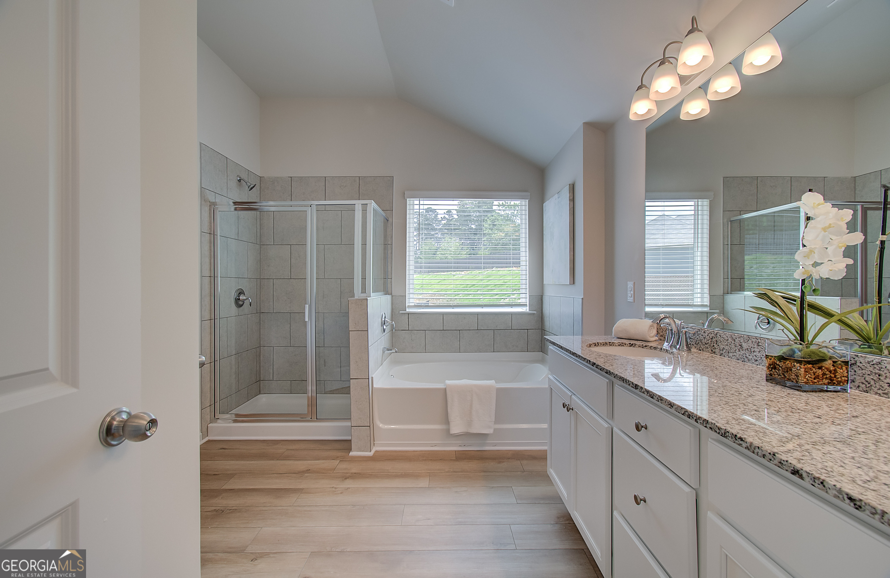 477 Collier Mls Road, Unit 20 Lawrenceville, GA 30045 - Photo 32 of 36 a bathroom with a granite countertop sink a large mirror and a shower