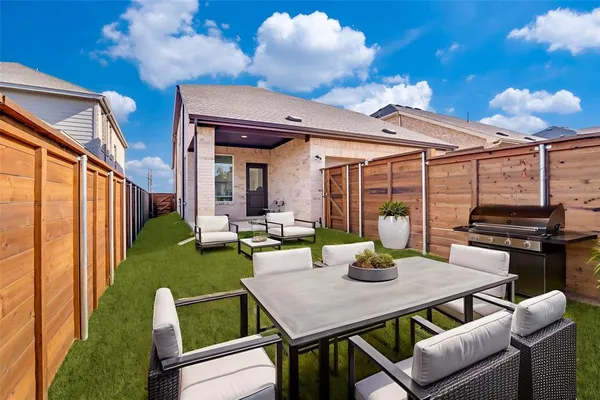 a view of a patio with table and chairs and a barbeque with potted plants