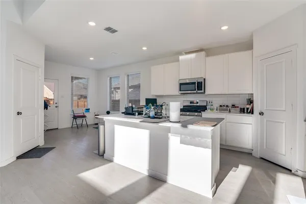 a kitchen with microwave a stove and cabinets