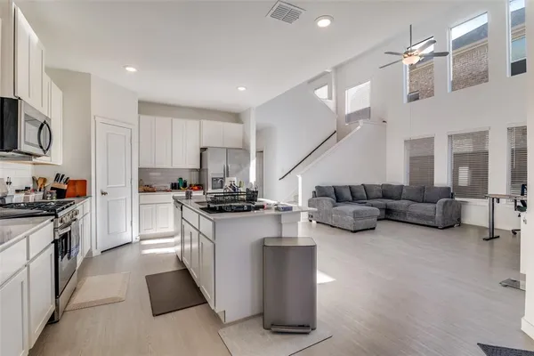 a kitchen with stainless steel appliances kitchen island granite countertop a stove and a sink