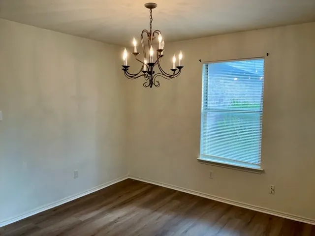 a view of a room with wooden floor and chandelier