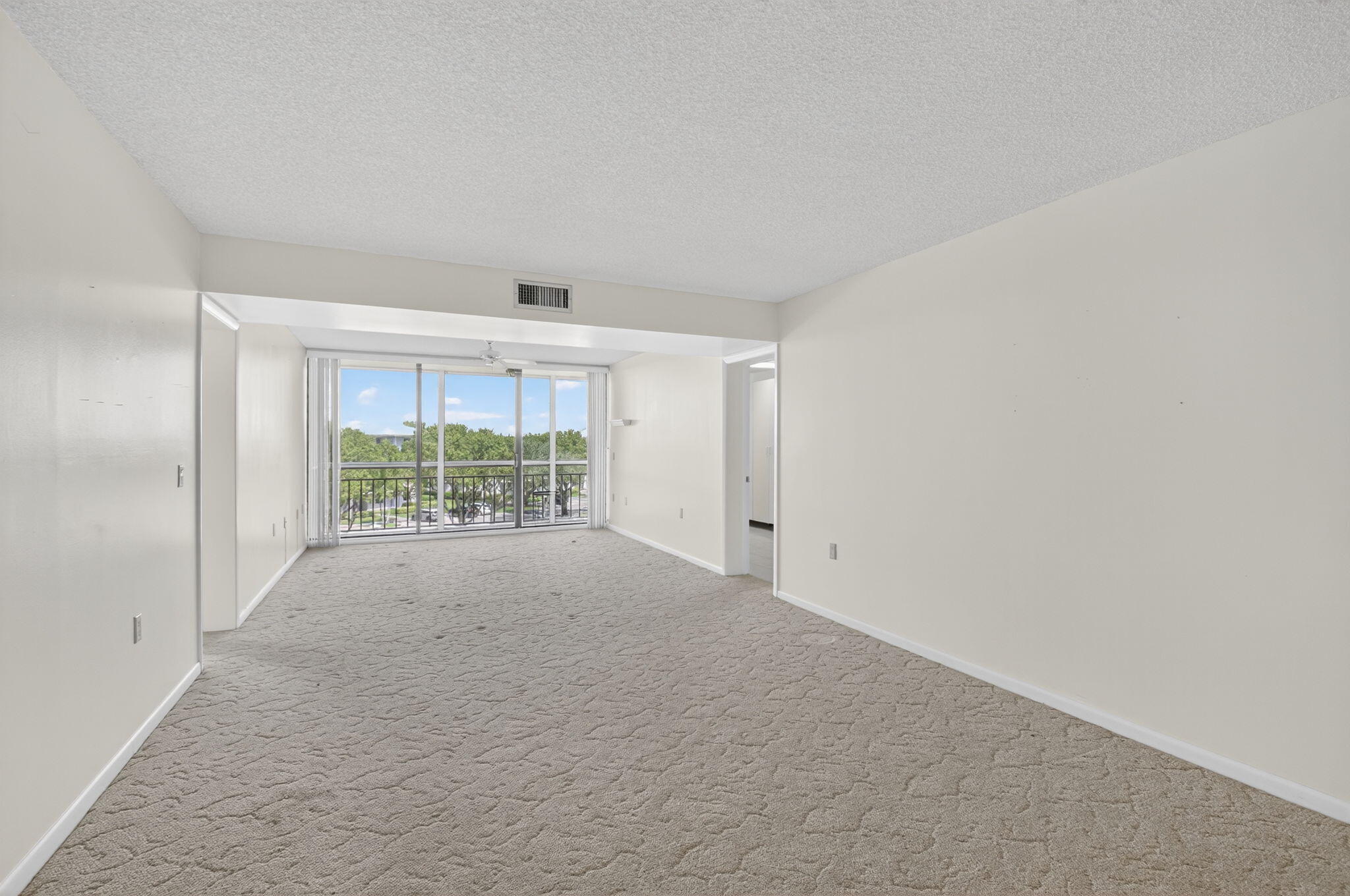 6193 Balboa Circle, Unit 403 Boca Raton, FL 33433 - Photo 4 of 25 a view of an empty room with a sliding door