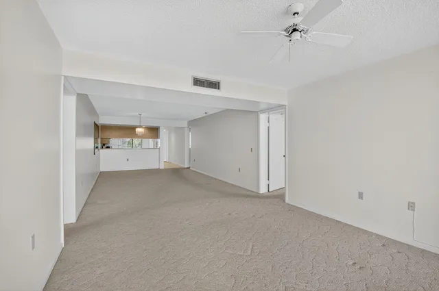 a view of a big room with chandelier fan and windows