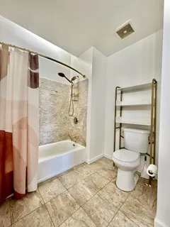 a bathroom with a toilet and a shower