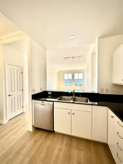 a kitchen with granite countertop a sink and cabinets
