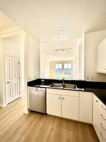 a kitchen with granite countertop a sink and cabinets
