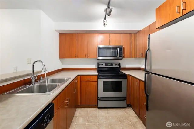 a kitchen with stainless steel appliances granite countertop a sink stove and refrigerator