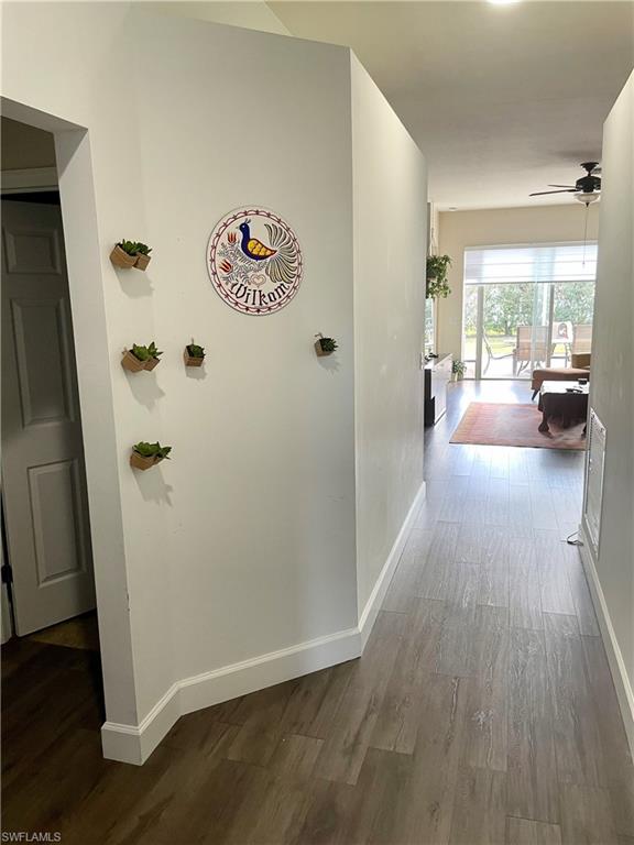 4176 Madison Street Ave Maria, FL 34142 - Photo 6 of 17 a view of a hallway with wooden floor and furniture