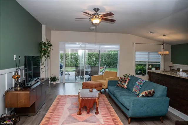 a living room with furniture a chandelier and a large window