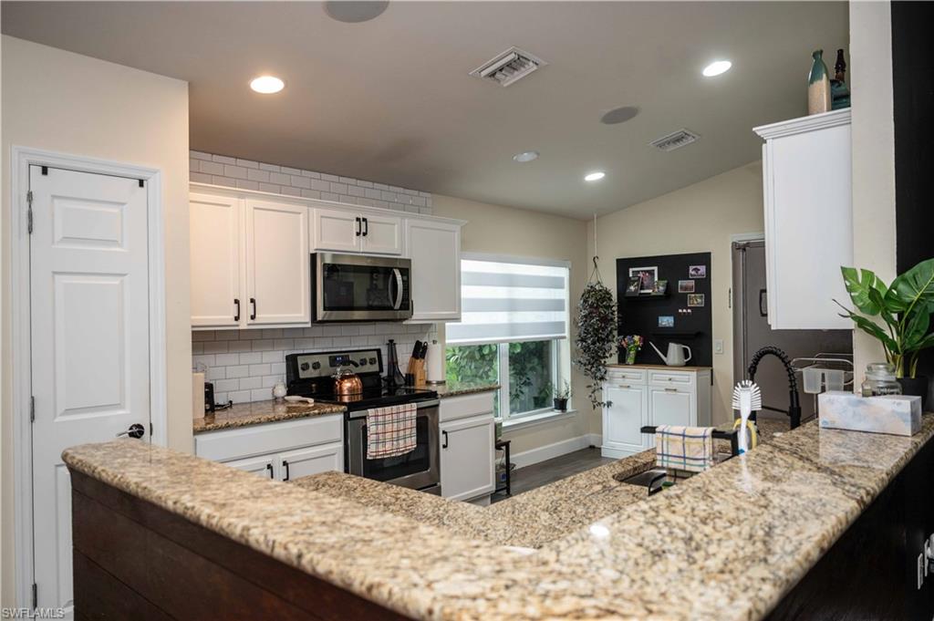 4176 Madison Street Ave Maria, FL 34142 - Photo 10 of 17 a kitchen with granite countertop kitchen island sink stove and refrigerator