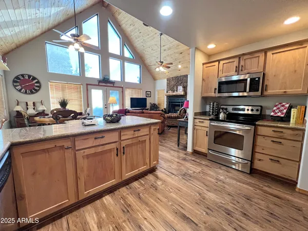 a kitchen with stainless steel appliances granite countertop a stove a sink and a microwave
