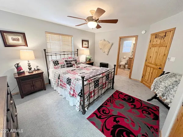 a bed room with a bed a mirror on dresser and a window