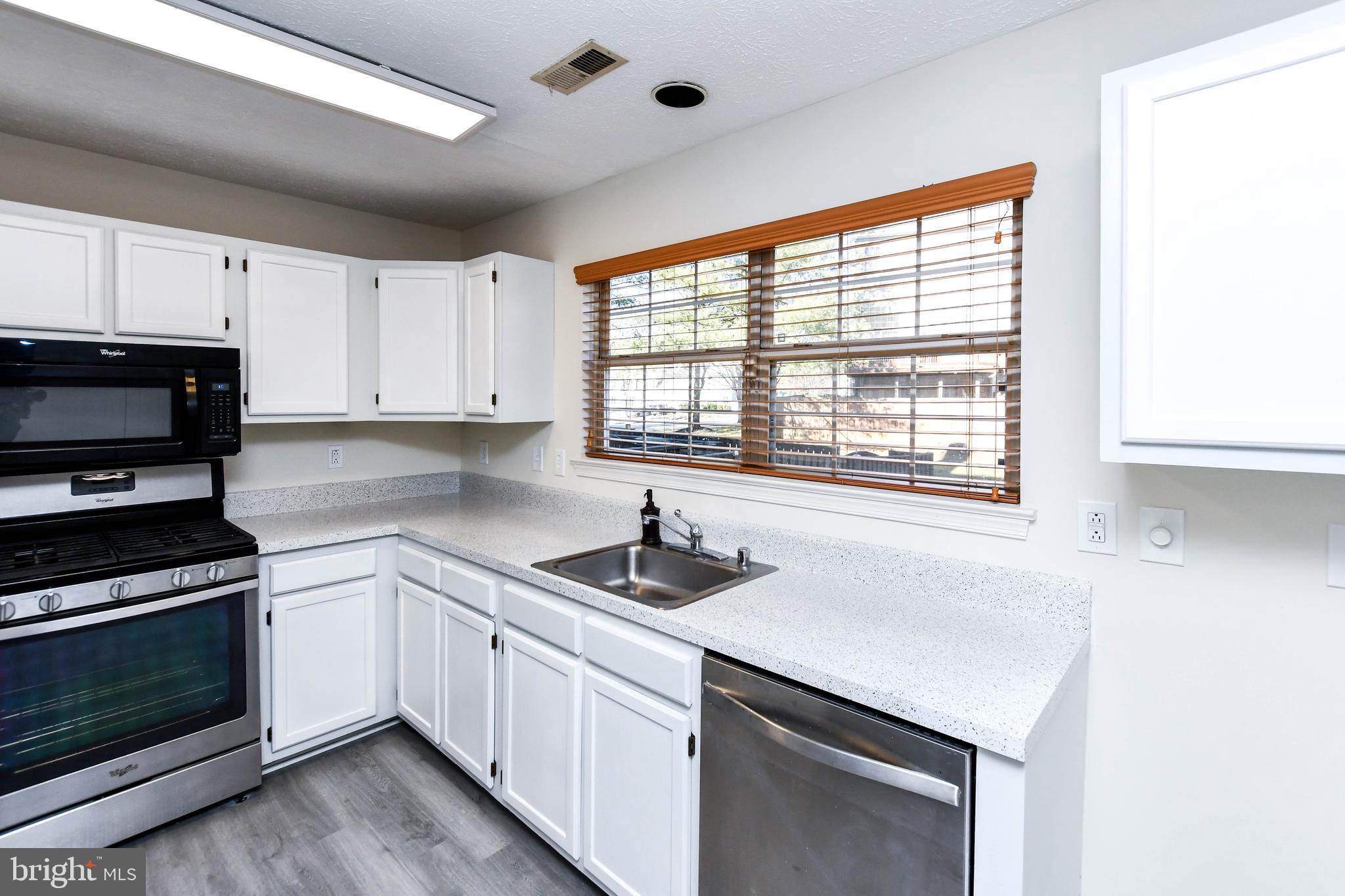 5908 Grenfell Loop Bowie, MD 20720 - Photo 16 of 65 a kitchen with a sink cabinets and window