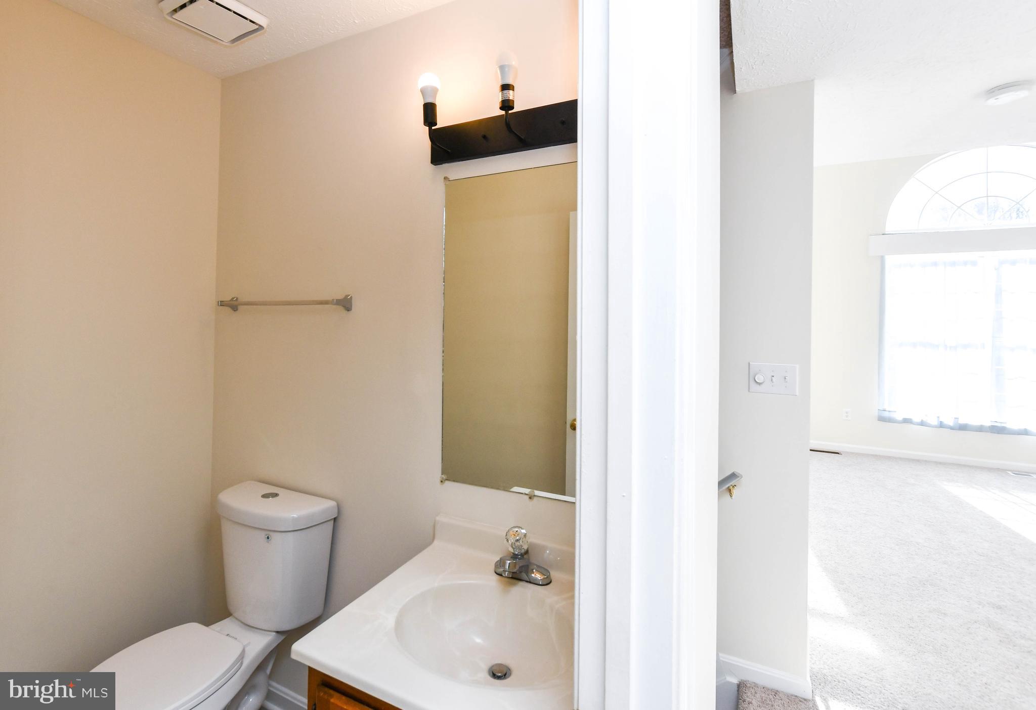 5908 Grenfell Loop Bowie, MD 20720 - Photo 23 of 65 a white toilet sitting next to a bathroom sink