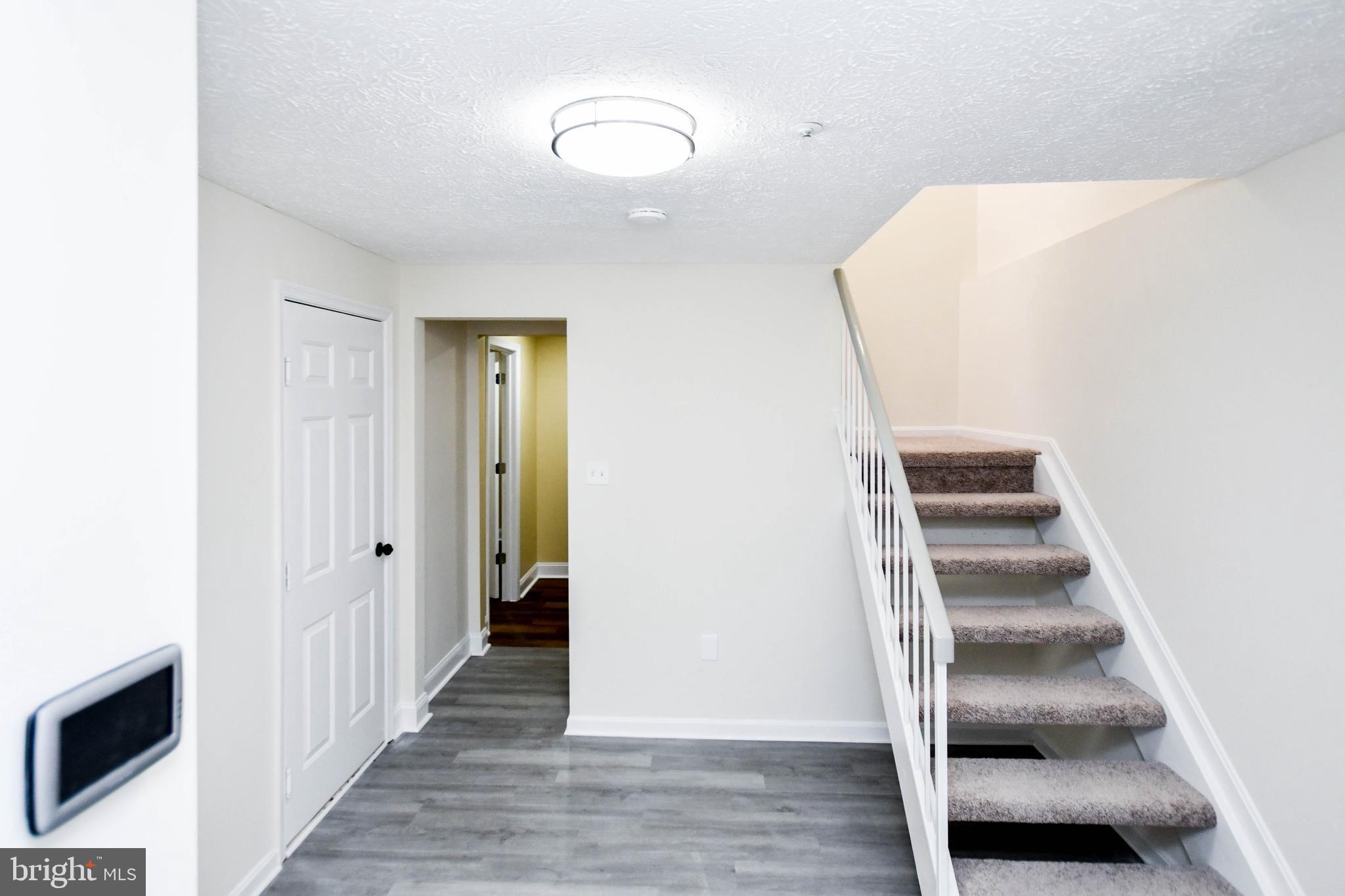 5908 Grenfell Loop Bowie, MD 20720 - Photo 4 of 65 a view of a hallway with entryway and wooden floor