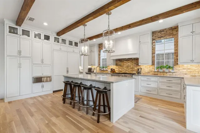 a kitchen with stainless steel appliances granite countertop a stove a sink dishwasher and cabinets with wooden floor