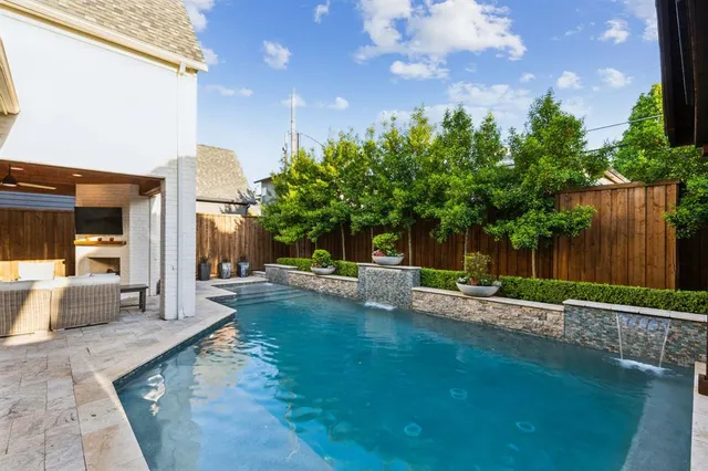 a view of a house with pool lawn chairs and a barbeque